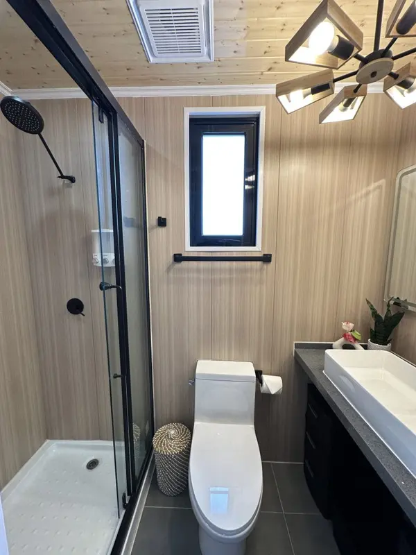 Bathroom with wood-look walls, a vessel sink vanity and a glass shower