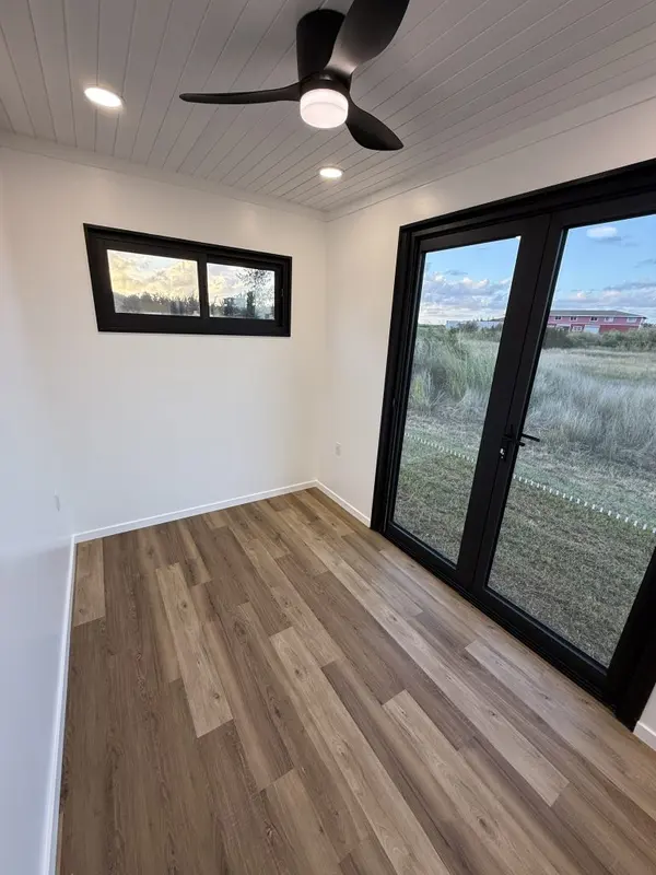 Bright bedroom with French doors opening onto a grassy field