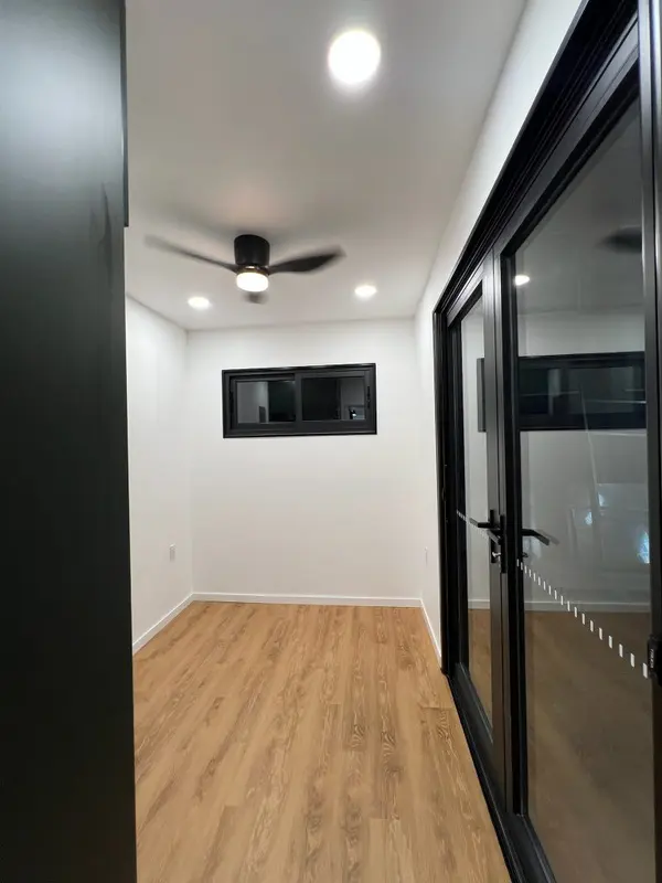 Bedroom with black-framed glass doors and a wood-look floor