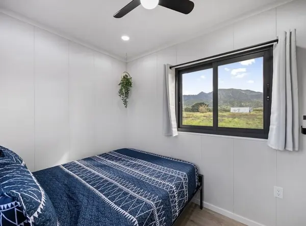 Bedroom with navy patterned bedding and a window framing mountain views