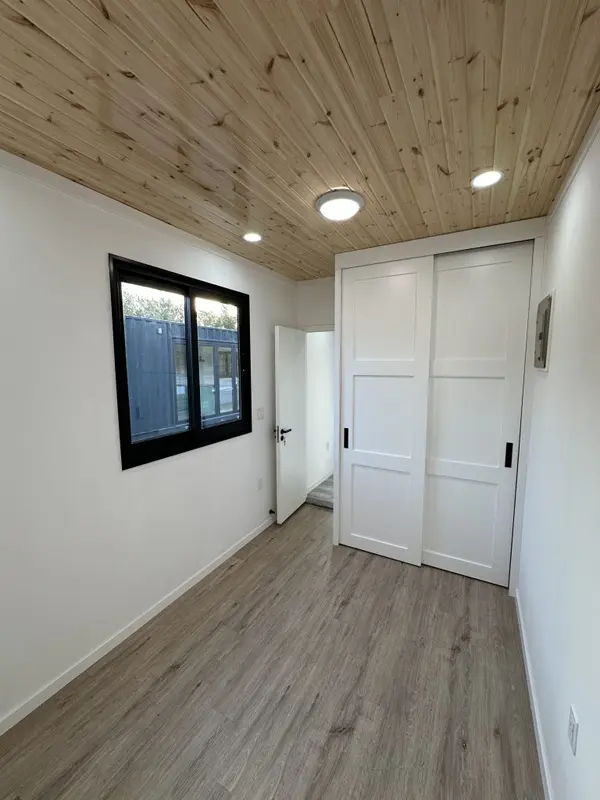 Bedroom with a white sliding-door closet and a pine ceiling