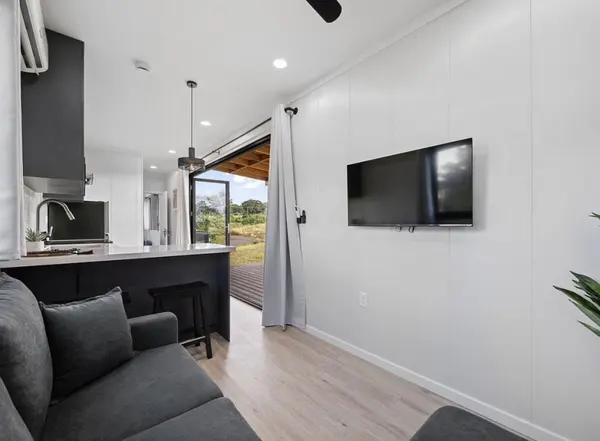 Living area looking through the kitchen to an open door and covered deck